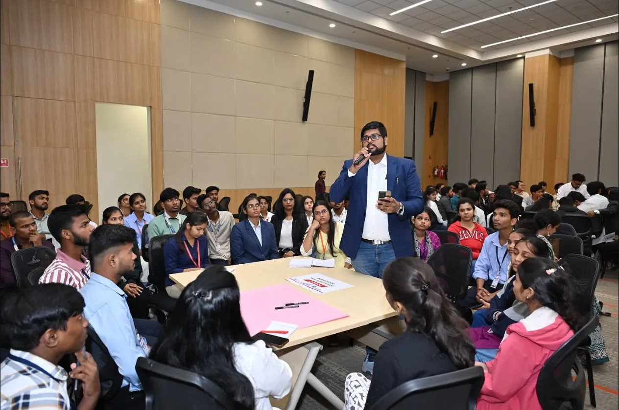 Angad Kulkarni speaking with a microphone during a student roundtable workshop